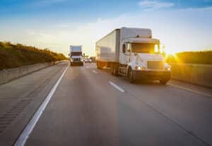 semi tractor trailer driving on the highway in the evening