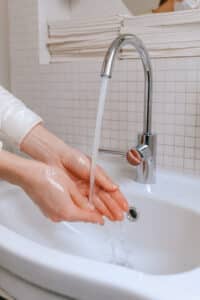 person washing hands to prevent spread of illness