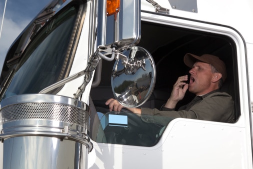 Tired at the wheel of 18 wheeler|Safety manager explaining to driver how to use electronic logbook at the office