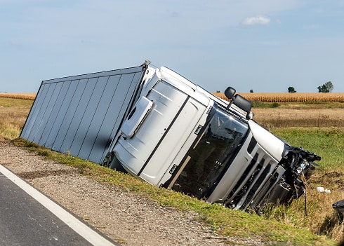 The truck lies in a side ditch after the road accident