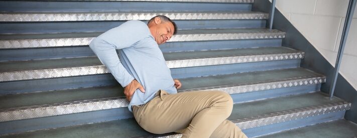 Man lying on staircase after a slip and fall accident